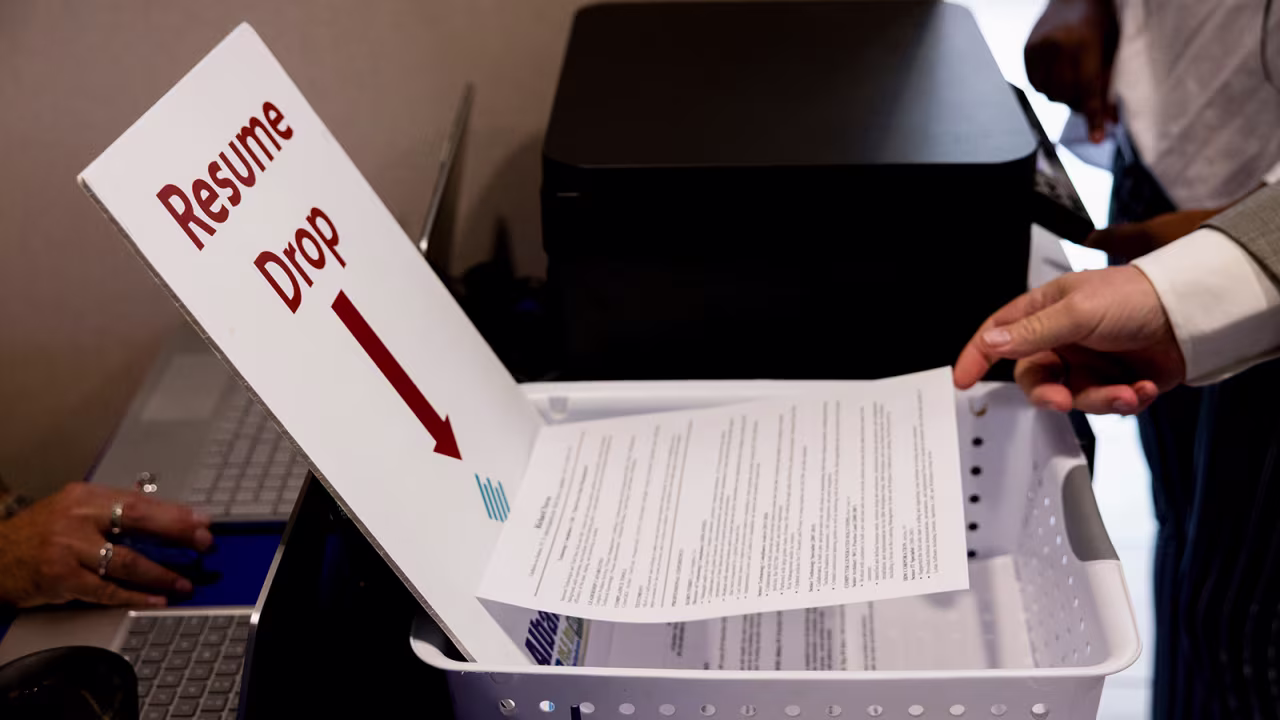 An attendee places their resume in a drop box at the Albany Job Fair in Latham, New York on October 2.