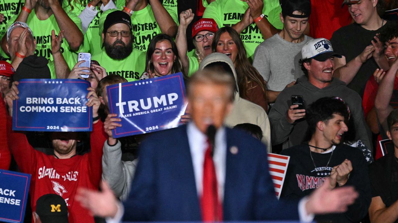 Supporters watch as former President and Republican presidential candidate Donald Trump speaks during a campaign rally in Saginaw, Michigan, on October 3, 2024.