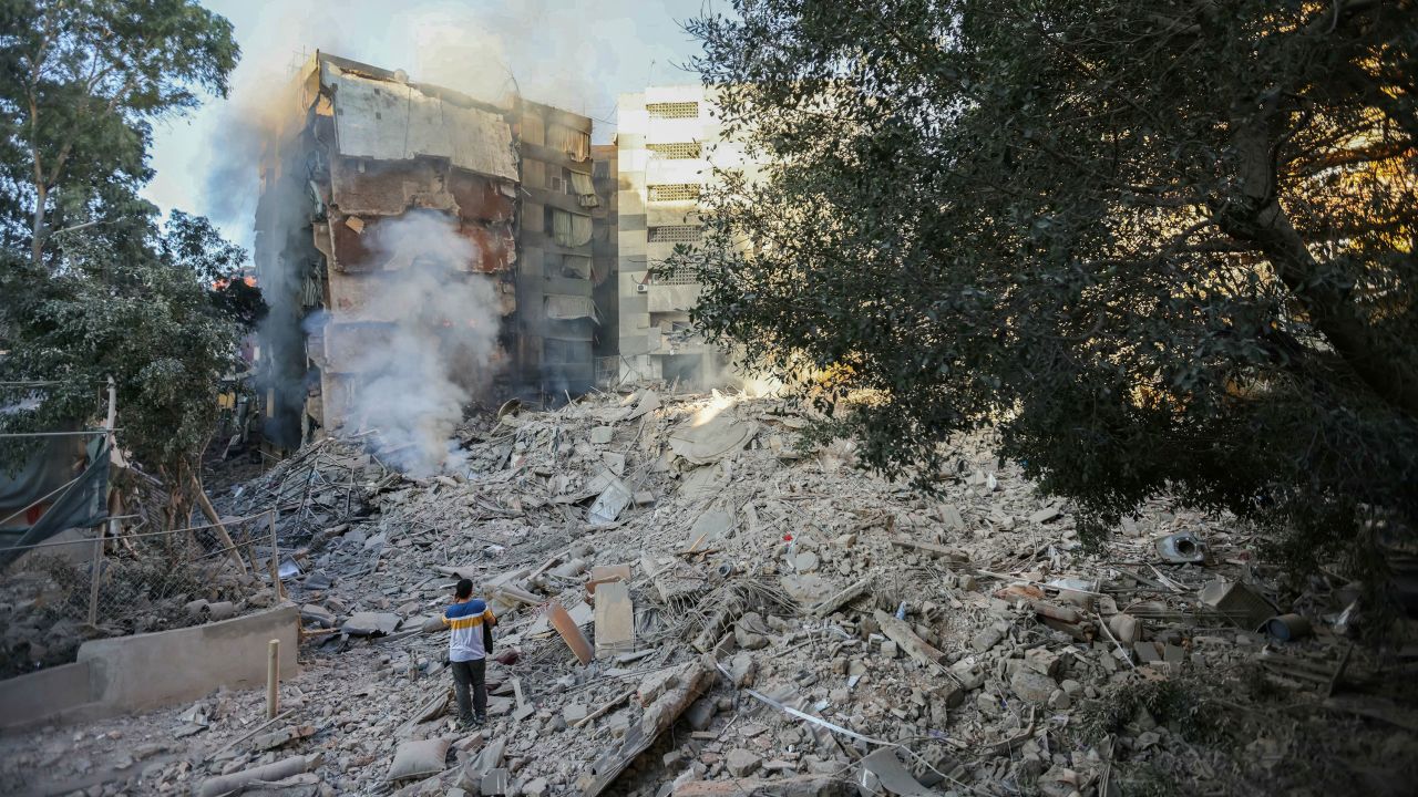 A man looks at smoke billowing from building rubble at the site of overnight Israeli airstrikes in Beirut's southern suburbs on Friday.