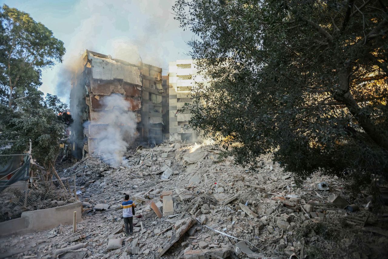 A man looks at smoke billowing from building rubble at the site of overnight Israeli airstrikes in Beirut's southern suburbs on October 4.