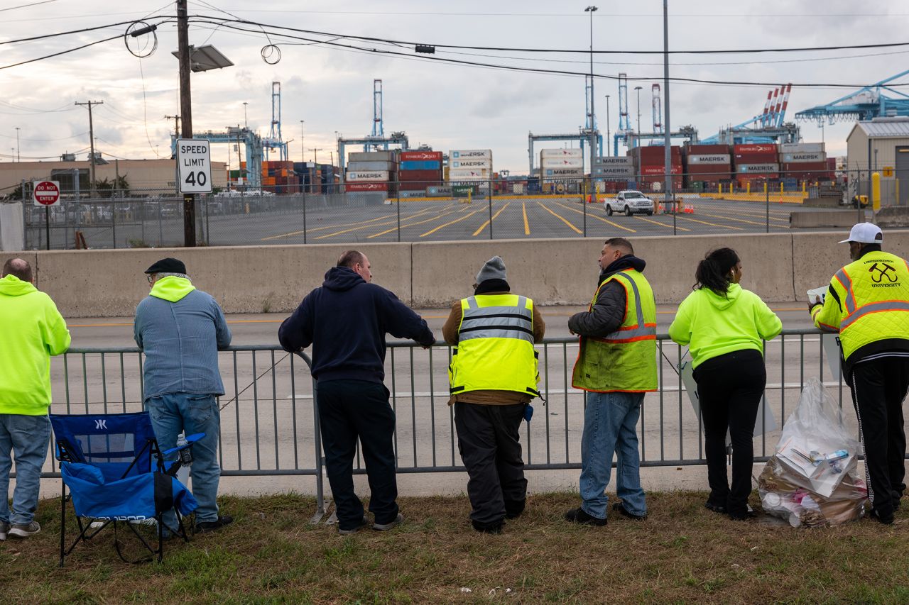 Dockworkers strike outside of the Port of Newark after members of the International Longshoremen’s Association, or ILA, began walking off the job after 12:01 a.m. ET on October 1 in Elizabeth, New Jersey. The strike of over 50,000 workers at ports along the East Coast and Texas comes after the just-expired master contract with the United States Maritime Alliance, or USMX. Workers are striking over wages, technology, and other issues.