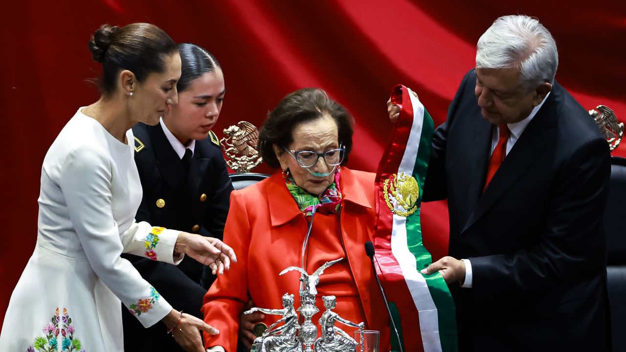 MEXICO CITY, MEXICO - OCTOBER 01: Outgoing president of Mexico Andres Manuel Lopez Obrador hands over the presidential sash to president of the Chamber of Deputies Ifigenia Martinez as new pesident Claudia Sheinbaum Pardo observes as part of the presidential inauguration on October 01, 2024 in Mexico City, Mexico. Claudia Sheinbaum takes office as the first female president of Mexico following an overwhelming victory in the presidential election. (Photo by Manuel Velasquez/Getty Images)