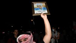 A person wearing a keffiyeh holds up a photo of Hamas leader Yahya Sinwar as people demonstrate to mark one year of the war between Hamas and Israel near the White House, in Washington, DC on October 5, 2024. (Photo by MATTHEW HATCHER / AFP) (Photo by MATTHEW HATCHER/AFP via Getty Images)