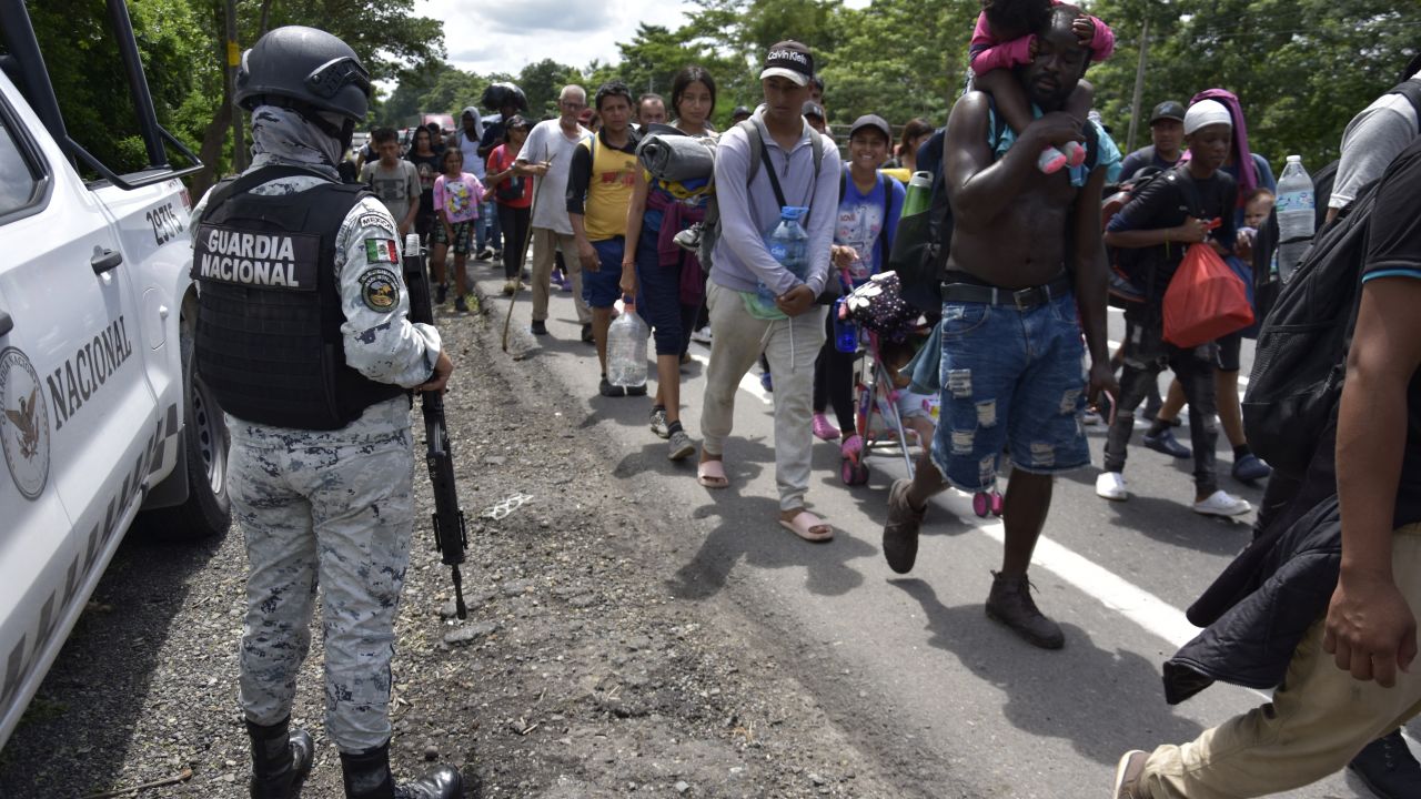 Members of the Mexican National Guard observe the migrants of different nationalities walk towards the United States on a highway in Tapachula, Chiapas State, Mexico, on October 5, 2024. (Photo by STRINGER / AFP) (Photo by STRINGER/AFP via Getty Images)