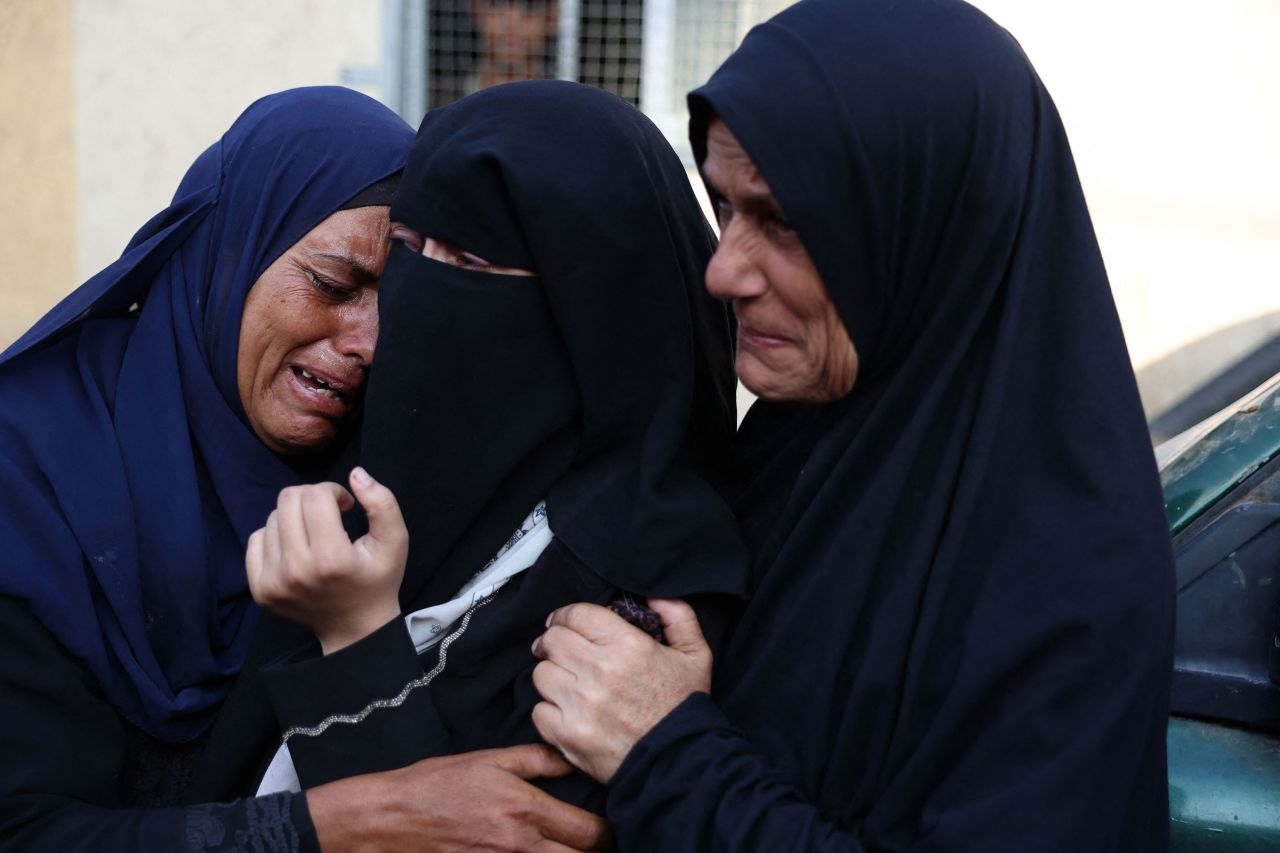 Palestinian women react upon identifying the bodies of victims of an Israeli strike that targeted a mosque-turned-shelter in Deir Al-Balah, in central Gaza, in the courtyard of the Al-Aqsa Martyrs Hospital on October 6.