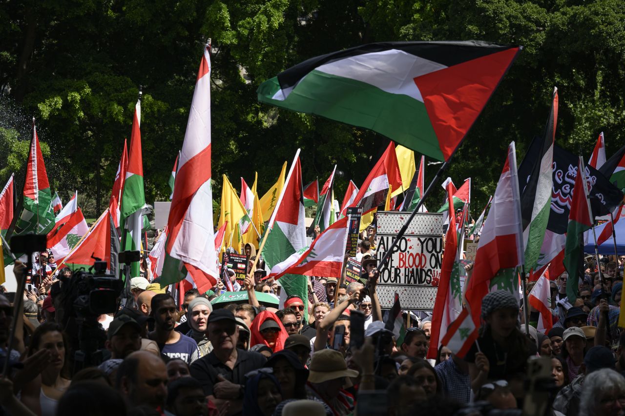 SYDNEY, AUSTRALIA - 2024/10/06: Protesters seen holding the national flags of Palestine and Lebanon at Hyde Park during the demonstration. Thousands of protestors gathered at Hyde Park, Sydney to march through the streets of the city in protest against the war in the Middle East and the humanitarian crisis in the Gaza Strip as the anniversary of October 7th draws near. (Photo by George Chan/SOPA Images/LightRocket via Getty Images)