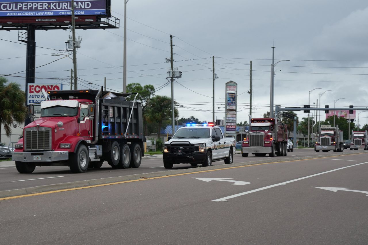 Pinellas County sheriff's deputies escort dump trucks filled with debris from Hurricane Helene to a landfill in Clearwater, Florida, on October 6, 2024, ahead of Hurricane Milton's landfall.