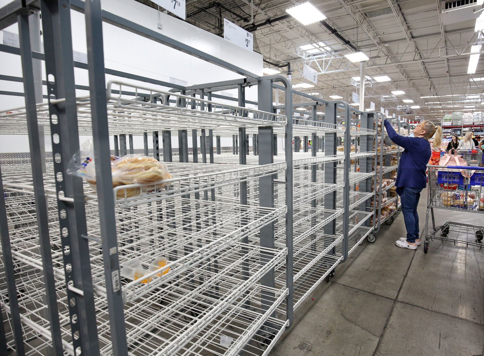 Customers check mostly empty bread shelves at a shopping warehouse in Kissimmee, Florida, on Sunday, October 6.