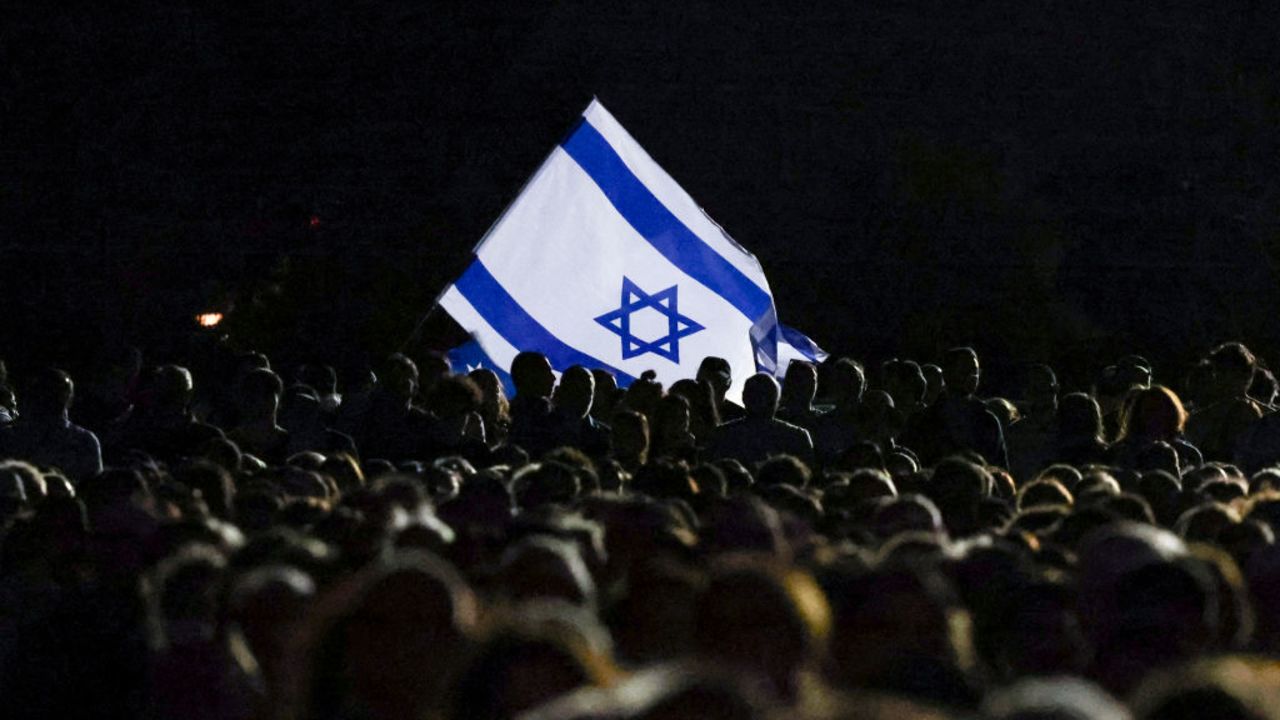 of the Australian Jewish community hold an Israeli flag during a memorial service in Sydney on October 7, 2024, to mark the anniversary of Palestinian militant group Hamas's October 7, 2023 attack on Israel. (Photo by DAVID GRAY / AFP) (Photo by DAVID GRAY/AFP via Getty Images)