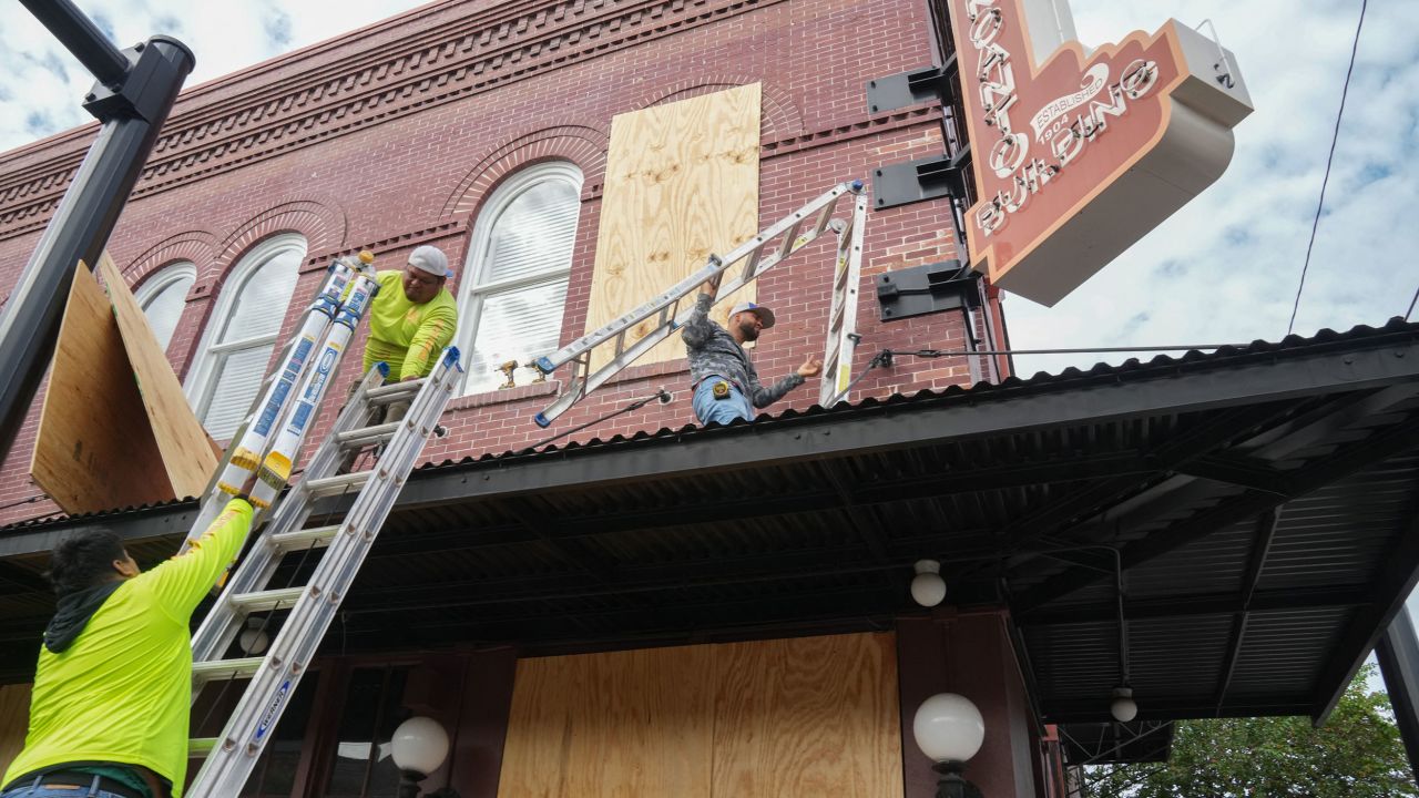 Contractors put plywood over windows at the El Encanto Building in Tampa, Florida, on Tuesday.