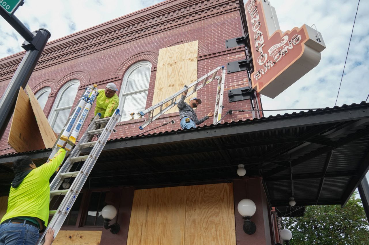 Contractors put plywood over windows at the El Encanto Building in Tampa, Florida, on Tuesday.