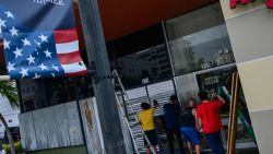 Employees of a local store protect their business by boarding up glass doors in Kissimmee, Florida, on October 8, 2024, ahead of the expected landfall of Hurricane Milton. Milton regained power on October 8 to become a Category 5 storm with maximum sustained winds of 165 mph (270 kph) as it barrels towards west-central coast of Florida forecast to make landfall late October 9, according to the National Hurricane Center. (Photo by GIORGIO VIERA / AFP) (Photo by GIORGIO VIERA/AFP via Getty Images)