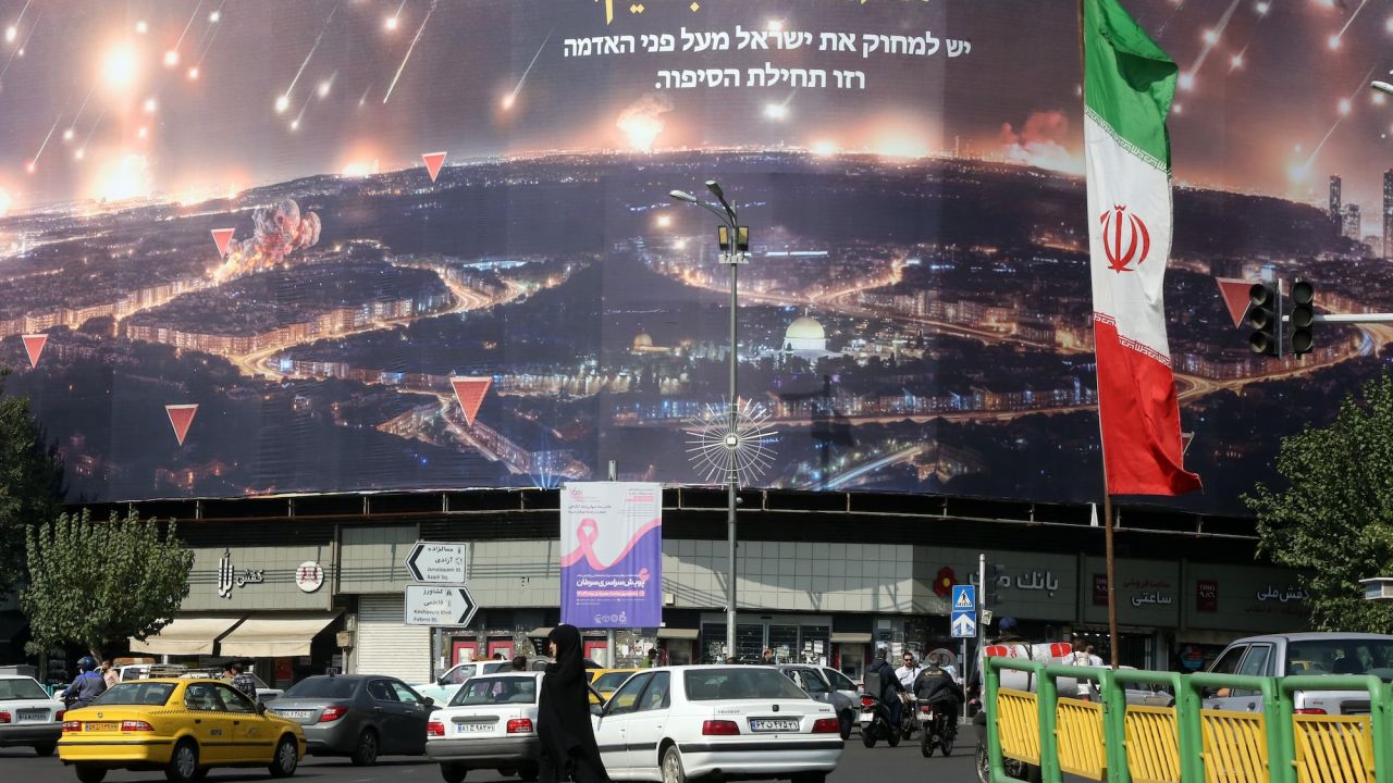 People walk on the streets of Tehran where Iranian flags and Hezbollah banners are seen, as the tensions between the two countries continue after Iran's missile attack on Israel in Tehran, Iran on October 09, 2024.