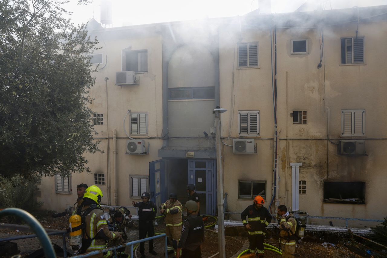 Emergency personnel are seen at a site hit by rockets fired from Lebanon in the northern Israeli city of Kiryat Shmona near the Lebanese border on Wednesday.