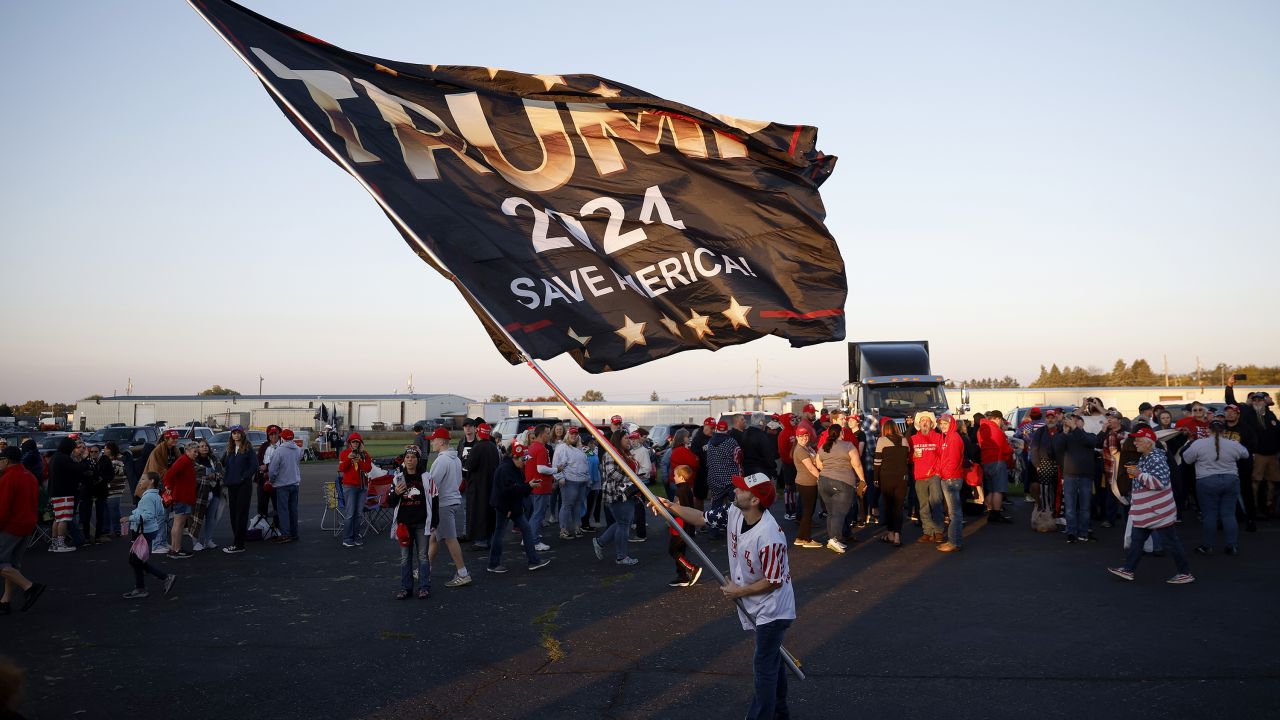 BUTLER, PENNSYLVANIA - OCTOBER 05: A man waves a flag as attendees wait in line prior to a rally by Republican presidential nominee, former U.S. President Donald Trump, at the Butler Farm Show Inc. on October 05, 2024 in Butler, Pennsylvania. Trump is holding a rally in Butler at the site of his first assassination attempt. (Photo by Kevin Dietsch/Getty Images)