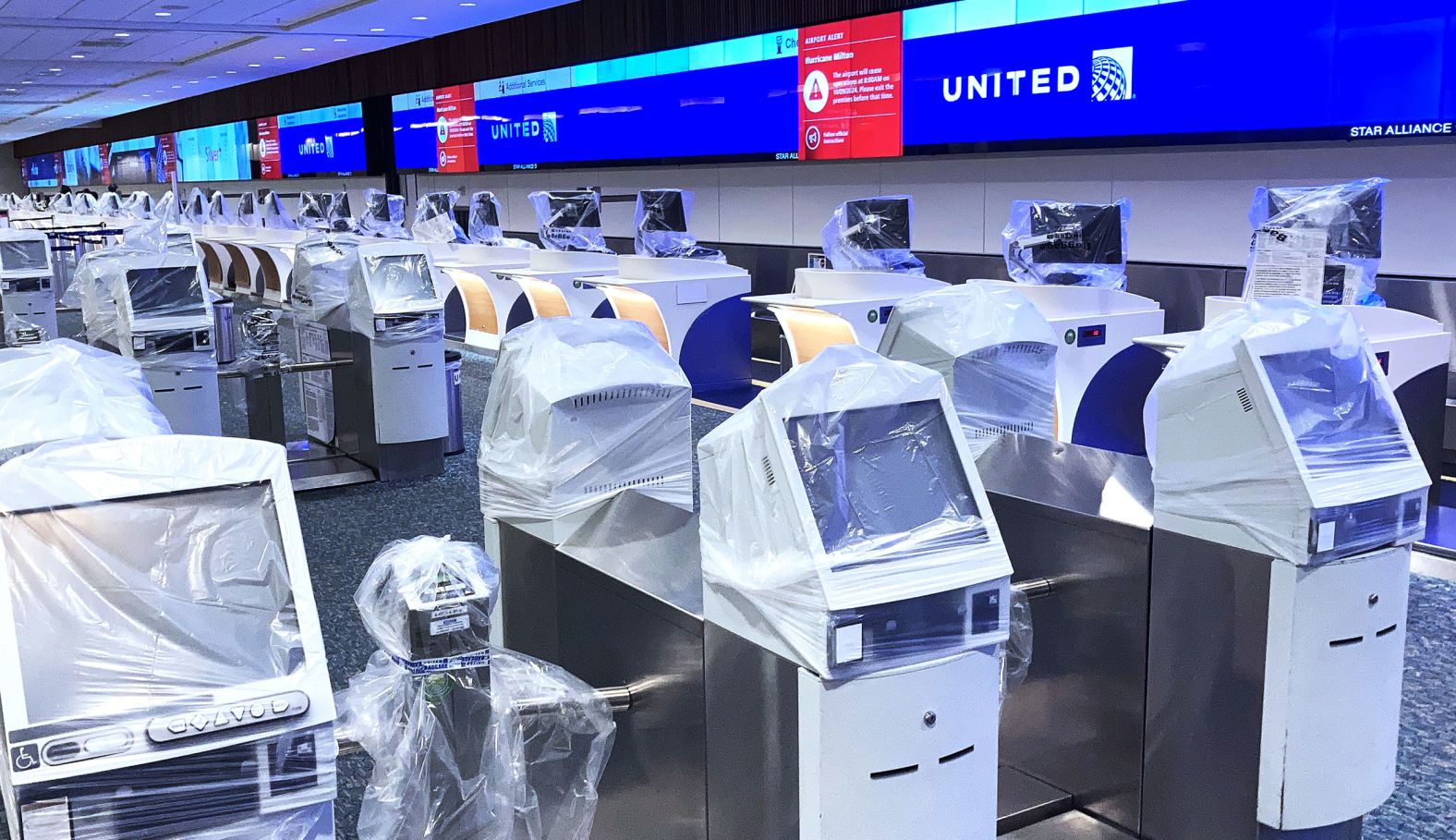 Check-in kiosks are covered in protective plastic at Orlando International Airport on Wednesday. The airport ceased operations at 8 a.m. Wednesday.