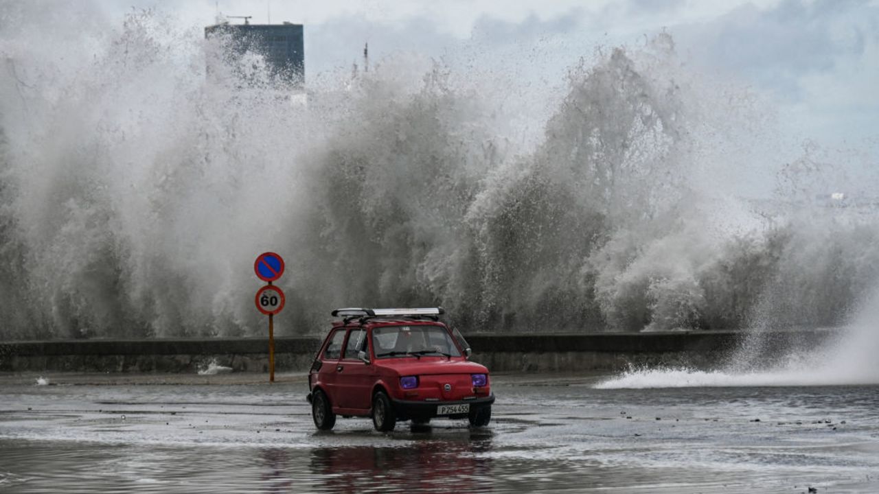 A car drives past waves crashing against the Malecon promenade in Havana due to the passage of Hurricane Milton on October 9, 2024. A "catastrophic" Hurricane Milton was closing in on the storm-battered state of Florida on Wednesday as US officials pleaded with residents to flee or risk dying. (Photo by YAMIL LAGE / AFP) (Photo by YAMIL LAGE/AFP via Getty Images)