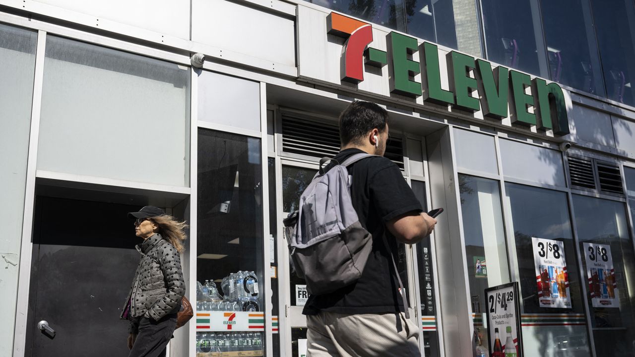 A person walks past a 7-Eleven convenience store in New York City on October 9, 2024. The Japanese owner of 7-Eleven said on Wednesday it had received a "revised" takeover offer from Canadian rival Alimentation Couche-Tard after rejecting an initial bid worth around $40 billion. 7-Eleven is the world's biggest convenience store chain and has more than 85,000 outlets worldwide, around a quarter of those in Japan.