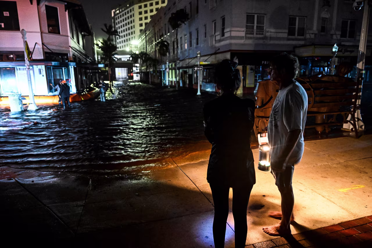 People watch water-flooded streets after Hurricane Milton made landfall in Fort Myers, Florida, on October 9, 2024.