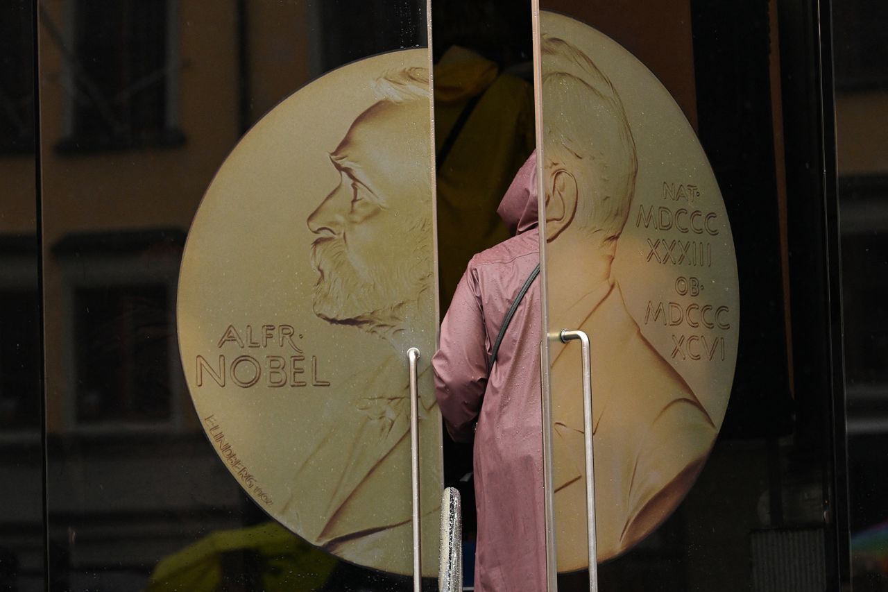 A woman opens the door to enter the Swedish Academy ahead of the announcement of the laureate of the 2024 Nobel Prize in Literature in Stockholm, Sweden, on October 10.