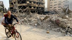 A man cycles past a destroyed building at the site of an overnight Israeli airstrikes that targeted a Beirut's southern suburb on October 10, 2024. The United States urged its ally Israel to avoid Gaza-like military action in Lebanon, after Prime Minister Benjamin Netanyahu said it could face "destruction" like the Palestinian territory. (Photo by AFP) (Photo by -/AFP via Getty Images)