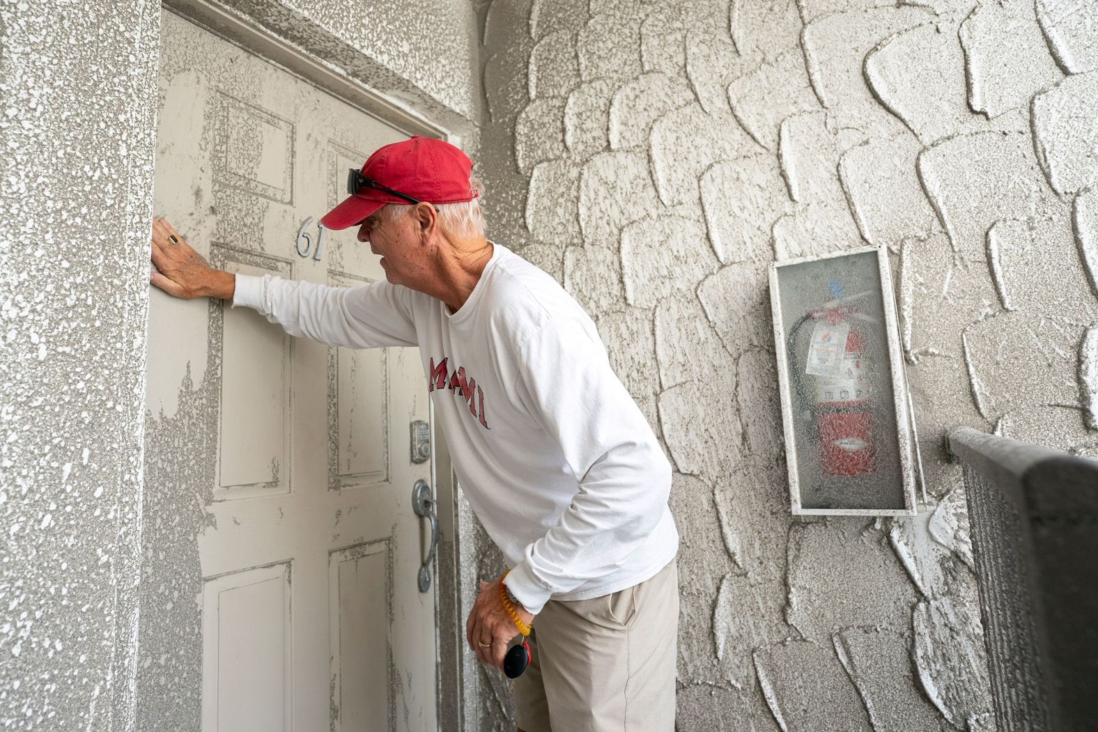 A man cleans sand off a beach-side condominium unit in Venice on Thursday.