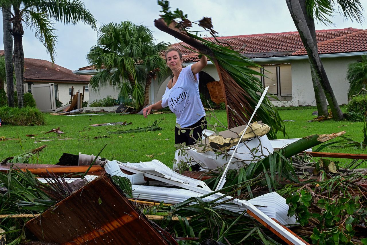 A woman collects debris caused a tornado in Cocoa Beach, Florida, on October 10, 2024.