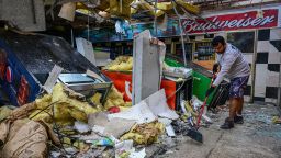 TOPSHOT - A man cleans debris inside a gas station store in Lakewood Park, Florida, after a tornado hit the area and caused severe damage as Hurricane Milton swept through Florida on October 10, 2024. At least 10 people were dead after Hurricane Milton smashed into Florida, US authorities said, after the monster weather system sent tornados spinning across the state and flooded swaths of the Tampa Bay area. (Photo by GIORGIO VIERA / AFP) (Photo by GIORGIO VIERA/AFP via Getty Images)