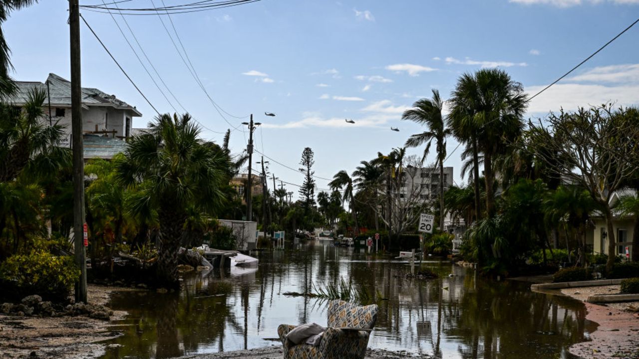 US military helicopters fly above flooded street after Hurricane Milton, in Siesta Key, Florida, on October 10, 2024. At least 10 people were dead after Hurricane Milton smashed into Florida, US authorities said October 10, 2024, after the monster weather system sent tornados spinning across the state and flooded swaths of the Tampa Bay area. (Photo by CHANDAN KHANNA / AFP) (Photo by CHANDAN KHANNA/AFP via Getty Images)