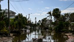 US military helicopters fly above flooded street after Hurricane Milton, in Siesta Key, Florida, on October 10, 2024. At least 10 people were dead after Hurricane Milton smashed into Florida, US authorities said October 10, 2024, after the monster weather system sent tornados spinning across the state and flooded swaths of the Tampa Bay area. (Photo by CHANDAN KHANNA / AFP) (Photo by CHANDAN KHANNA/AFP via Getty Images)