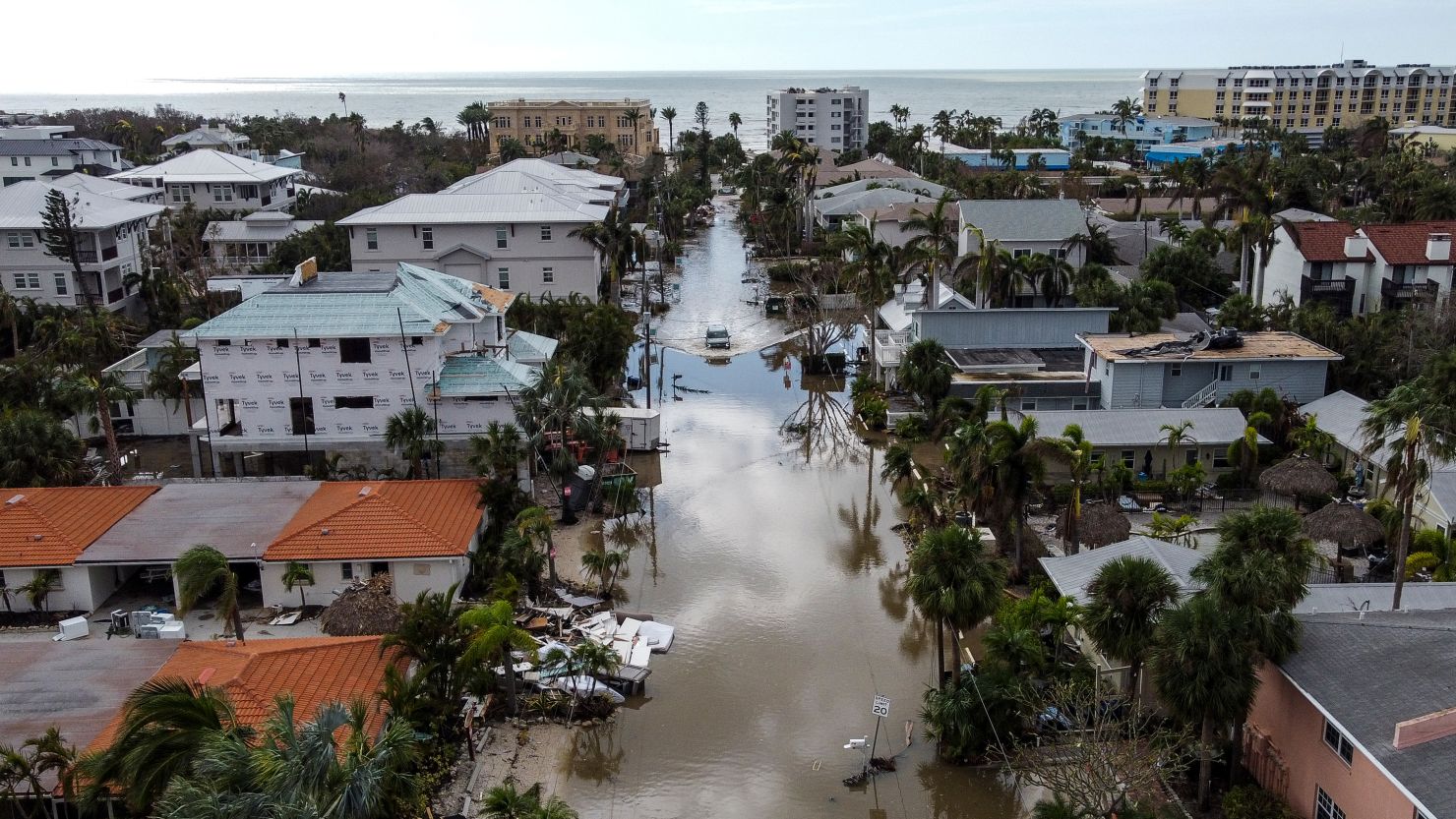 In this aerial photo, a vehicle drives though a flooded street after Hurricane Milton, in Siesta Key, Florida, on October 10, 2024.