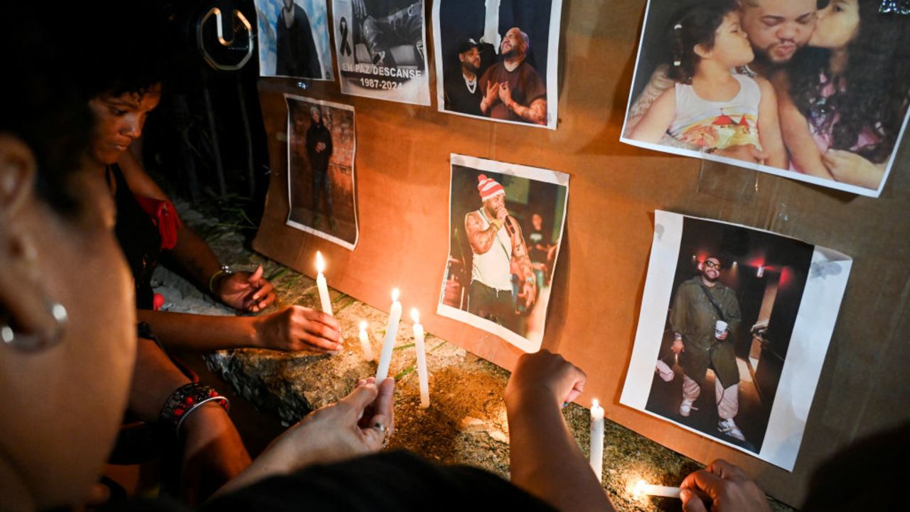 Cubans light candles next to pictures of late reggaeton singer Jose Manuel Carbajal 'El Taiger' as they pay tribute in Havana on October 10, 2024. Cuban musician José Manuel Carvajal, known as El Taiger, died Thursday in Miami at the age of 37, after a week hospitalized in critical condition due to a gunshot wound to the head, the Cuban Music Institute and relatives of the singer reported. (Photo by YAMIL LAGE / AFP) (Photo by YAMIL LAGE/AFP via Getty Images)