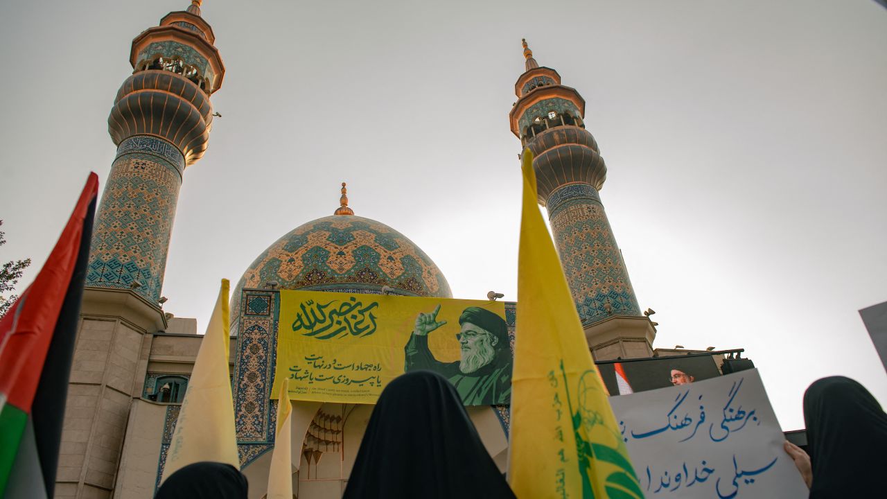 Iranians hold Hezbollah flags during an anti-Israel rally in Tehran, on October 8, 2024. Iran warned Israel on October 8 against attacking any of its infrastructure amid fears of a possible Israeli assault on oil or nuclear sites following Iran's missile barrage last week. Tehran says its attack on Israel, when some 200 missiles were fired, was a response to the death in a Beirut air strike of Hassan Nasrallah, leader of the Iran-backed Lebanese movement Hezbollah, and of Hamas political leader Ismail Haniyeh in Tehran. (Photo by Hossein Beris / Middle East Images / Middle East Images via AFP) (Photo by HOSSEIN BERIS/Middle East Images/AFP via Getty Images)