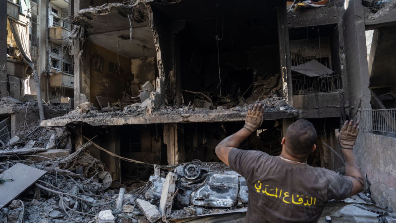 BEIRUT, LEBANON - OCTOBER 11: A rescue worker gestures to people in a ruined building at the site of an Israeli airstrike on apartment block on October 11, 2024 in Beirut, Lebanon. At least 22 people died, and over 100 were injured, in the strike in central Beirut last night, according to Lebanese officials. Israel said the target was a high-ranking Hezbollah official. (Photo by Carl Court/Getty Images)