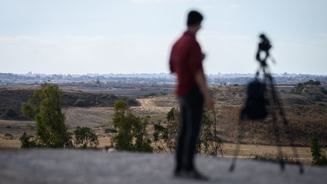 A journalist looks towards Gaza from a viewpoint in Southern Israel on October 07, 2024 in Sderot, Israel.