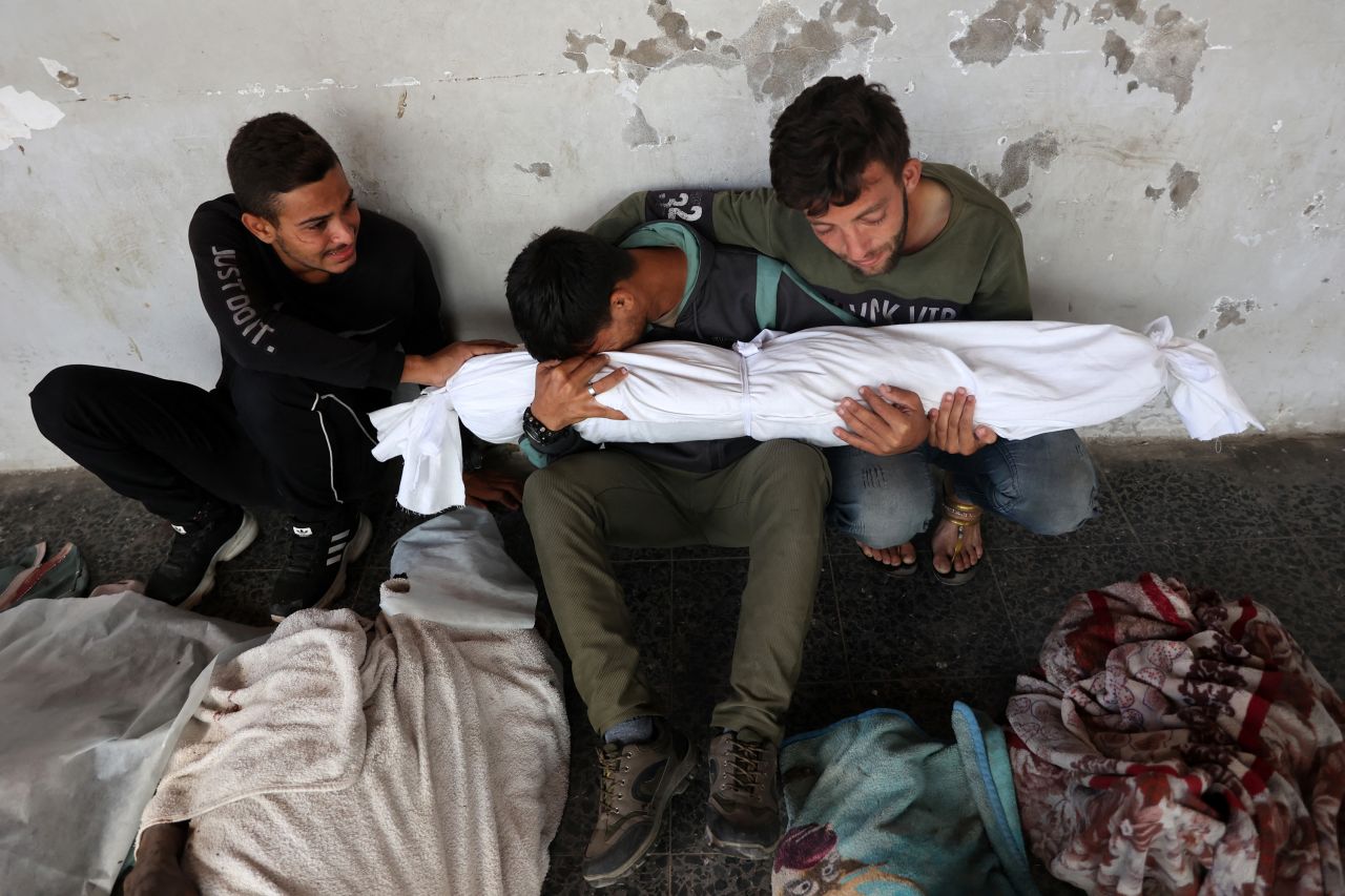 Ali Assaf, center, is comforted in front of the Al-Maamadani Hospital as he mourns his family members who were killed by Israel in an overnight airstrike, in the Jabalya refugee camp in Gaza, on October 12. He is reportedly the only survivor from his family.