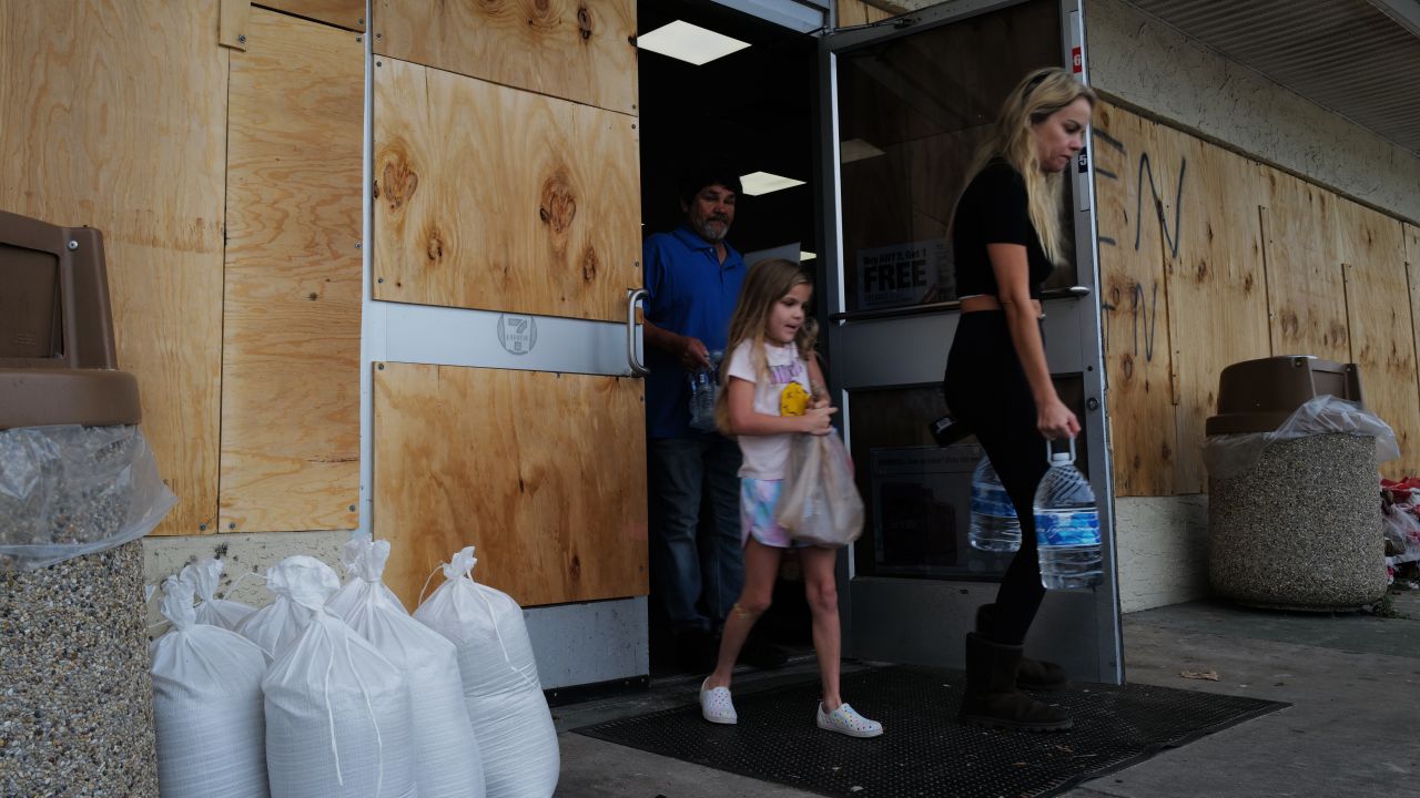 ST. PETERSBURG, FLORIDA - OCTOBER 08: People walk in and out of a boarded-up 7-11 store as the state prepares for the arrival of Hurricane Milton on October 08, 2024, in St. Petersburg, Florida. Milton, which comes just after the recent catastrophic Hurricane Helene, has strengthened to a Category 4 storm as it approaches Florida’s Gulf Coast and is expected to make landfall late Wednesday. (Photo by Spencer Platt/Getty Images)