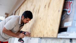 NAPLES, FLORIDA - OCTOBER 08: Sk Islam puts plywood over a store's windows before Hurricane Milton's arrival on October 08, 2024 in Naples, Florida. People are preparing for the storm, which could be a Cat 3, when it makes landfall on Wednesday evening. (Photo by Joe Raedle/Getty Images)