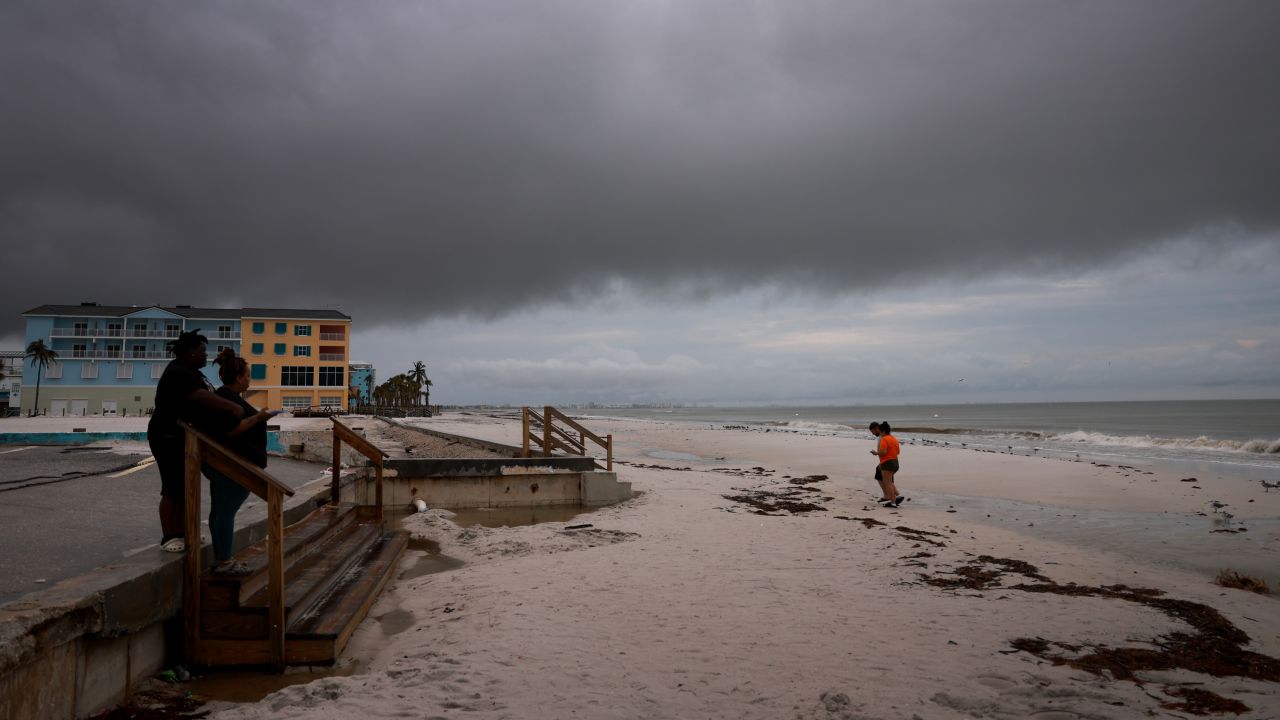 People visit the beach as storm clouds hang overhead before Hurricane Milton's arrival in Fort Myers, Florida, on October 8.