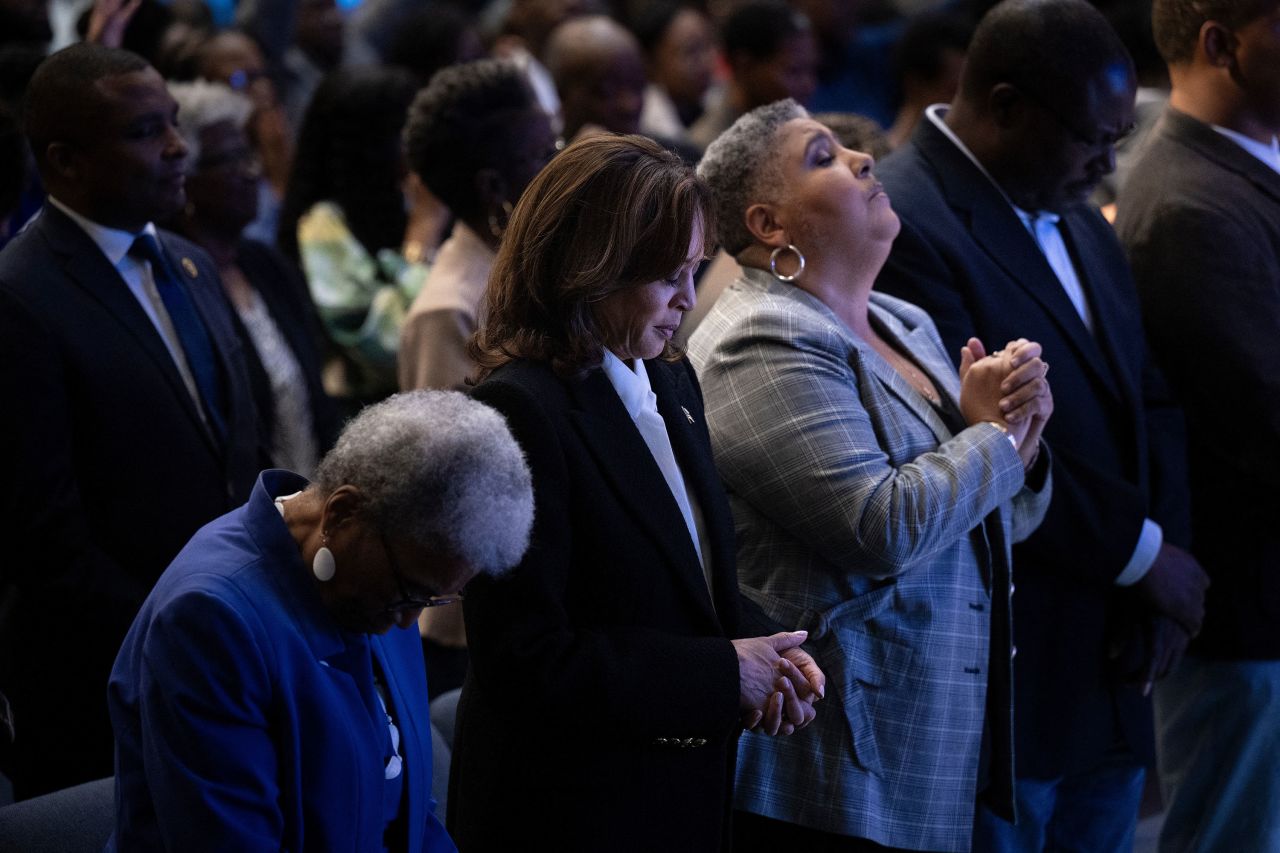 Harris prays during the service.