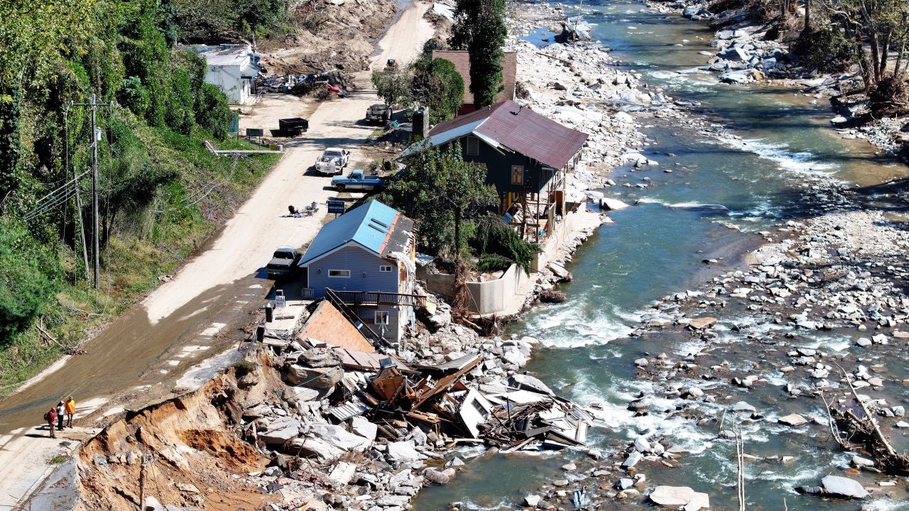 BAT CAVE, NORTH CAROLINA - OCTOBER 08: An aerial view of people standing near destroyed and damaged buildings in the aftermath of Hurricane Helene flooding on October 8, 2024 in Bat Cave, North Carolina. Bat Cave was particularly hard hit by flooding. Recovery efforts continue as the death toll has risen to over 230 while the powerful Hurricane Milton is on track to make landfall in Florida. (Photo by Mario Tama/Getty Images)