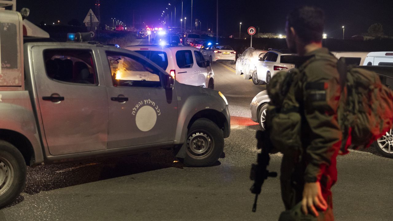 An Israeli soldier secures a road after a drone attack that caused mass casualties on October 13, in Binyamina, Israel. More than 60 people were reportedly injured following a drone strike launched by Hezbollah.