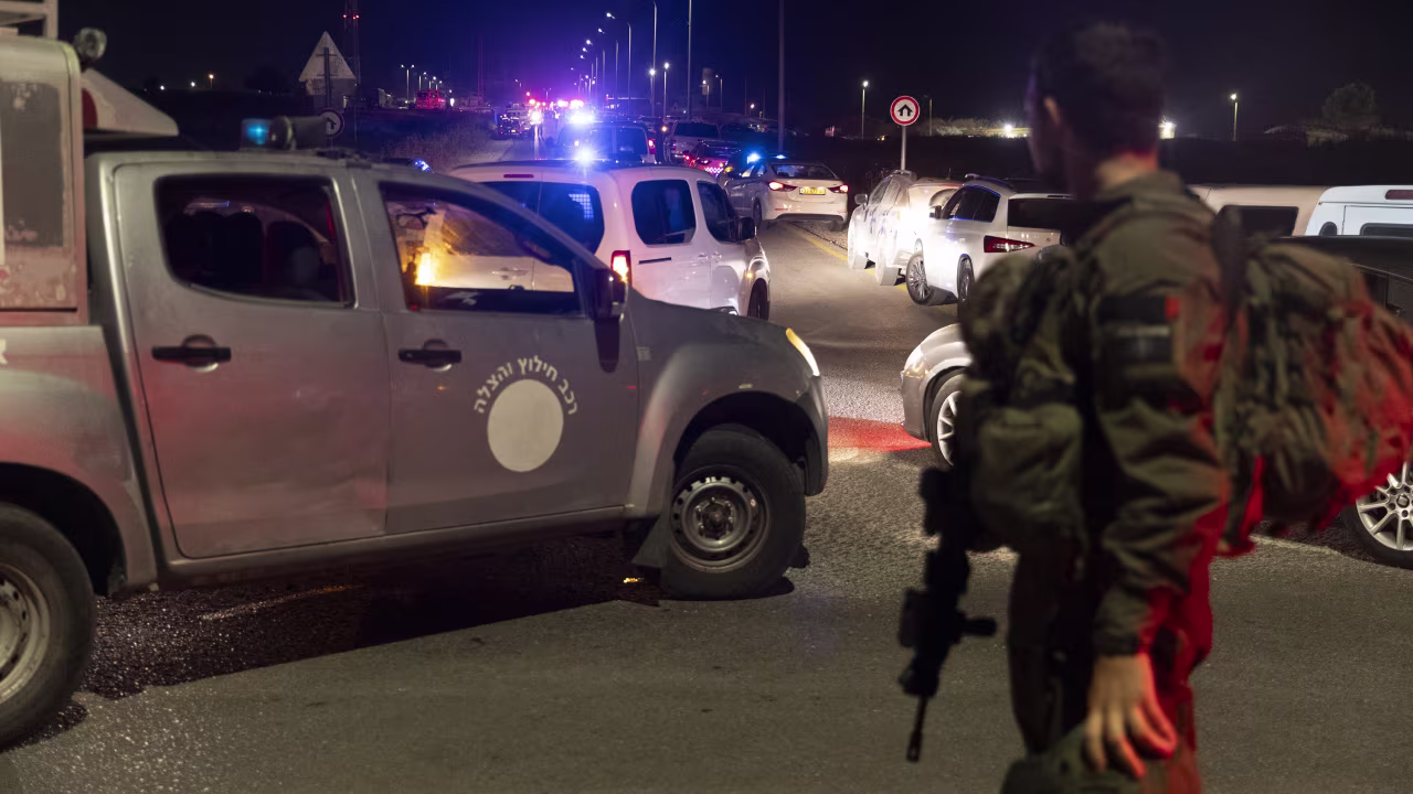 An Israeli soldier secures a road after a drone attack that caused mass casualties on October 13, in Binyamina, Israel. More than 60 people were reportedly injured following a drone strike launched by Hezbollah.