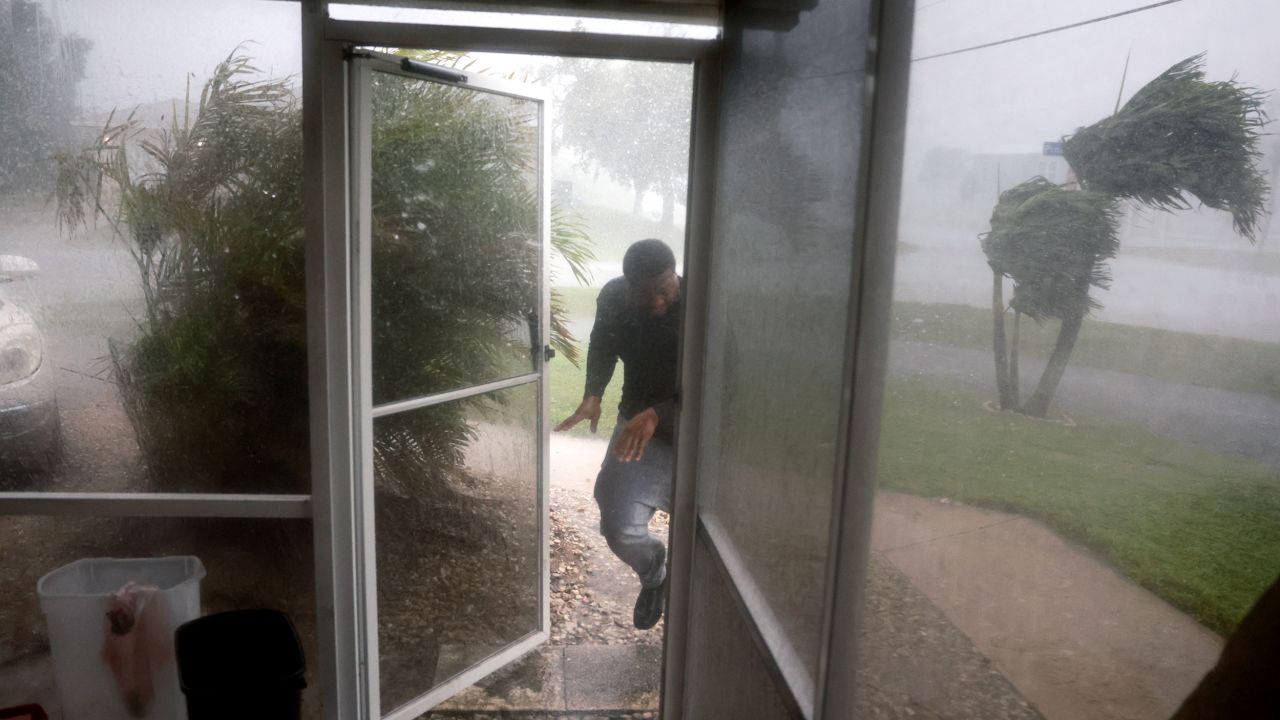 Chris Williams runs through a rain storm as he packs his car to evacuate his apartment before Hurricane Milton's arrival on Wednesday in Fort Myers, Florida.