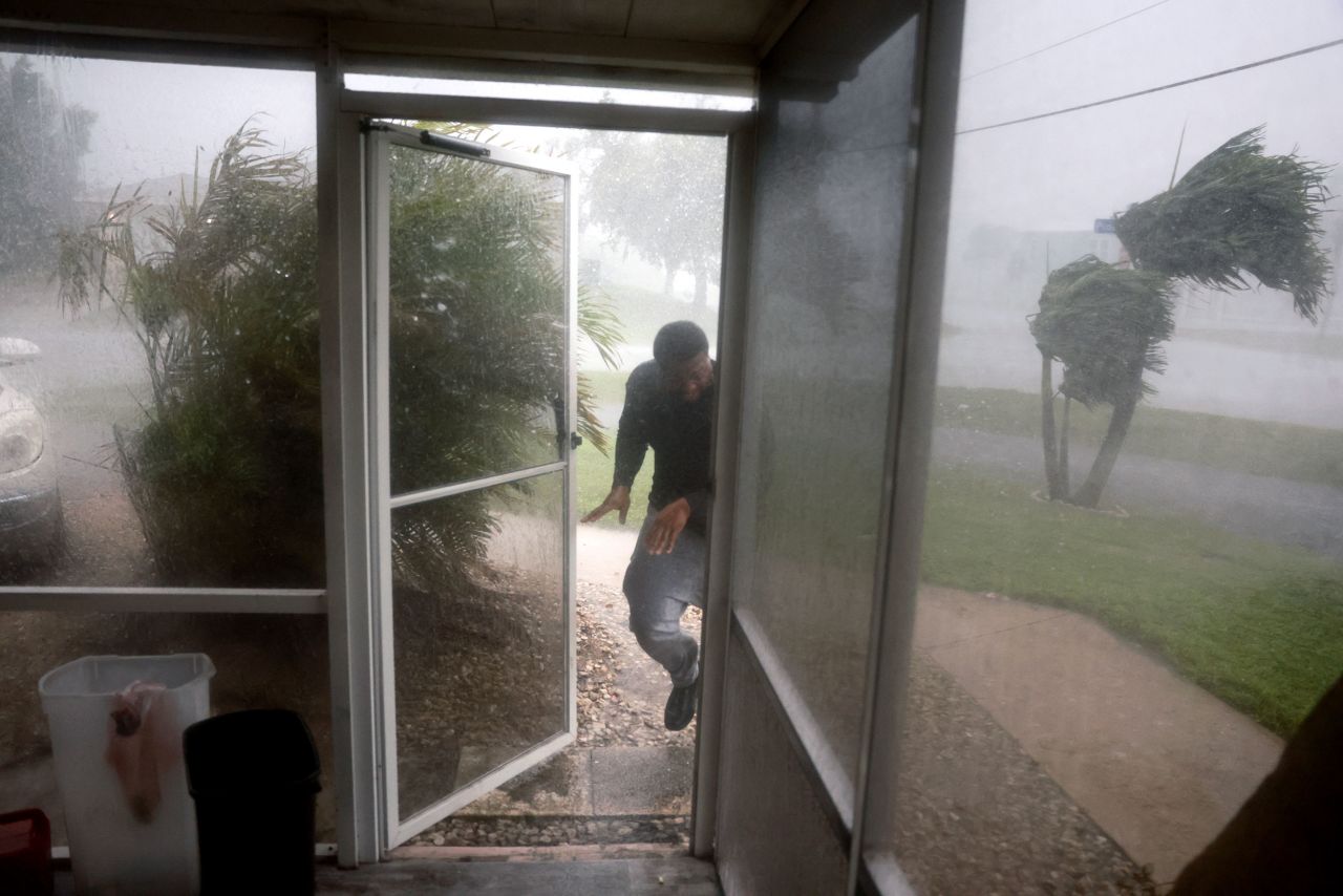 Chris Williams runs through a rain storm as he packs his car to evacuate his apartment before Hurricane Milton's arrival on Wednesday in Fort Myers, Florida.