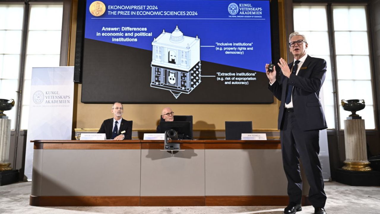 Academy of Sciences permanent secretary Jan Teorell, of the Nobel assembly delivers a press conference in front of a screen showing results of the research of laureates of the 2024 Sveriges Riksbank Prize in Economic Sciences in Memory of Alfred Nobel, Daron Acemoglu, Simon Johnson and James A Robinson during the announcement by the Royal Swedish Academy of Sciences in Stockholm, Sweden on October 14, 2024. The Nobel prize in economics was awarded on October 14, 2024, to Turkish-American Daron Acemoglu and British-Americans Simon Johnson and James Robinson for research into wealth inequality between nations. The trio was honoured "for studies of how institutions are formed and affect prosperity", the jury said. (Photo by Christine Olsson/TT / TT NEWS AGENCY / AFP) / Sweden OUT (Photo by CHRISTINE OLSSON/TT/TT NEWS AGENCY/AFP via Getty Images)