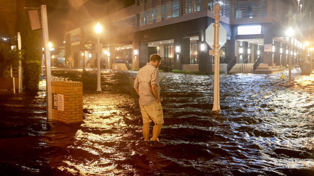 Brandon Marlow walks through a flooded street in Fort Myers, Florida, on Wednesday night.