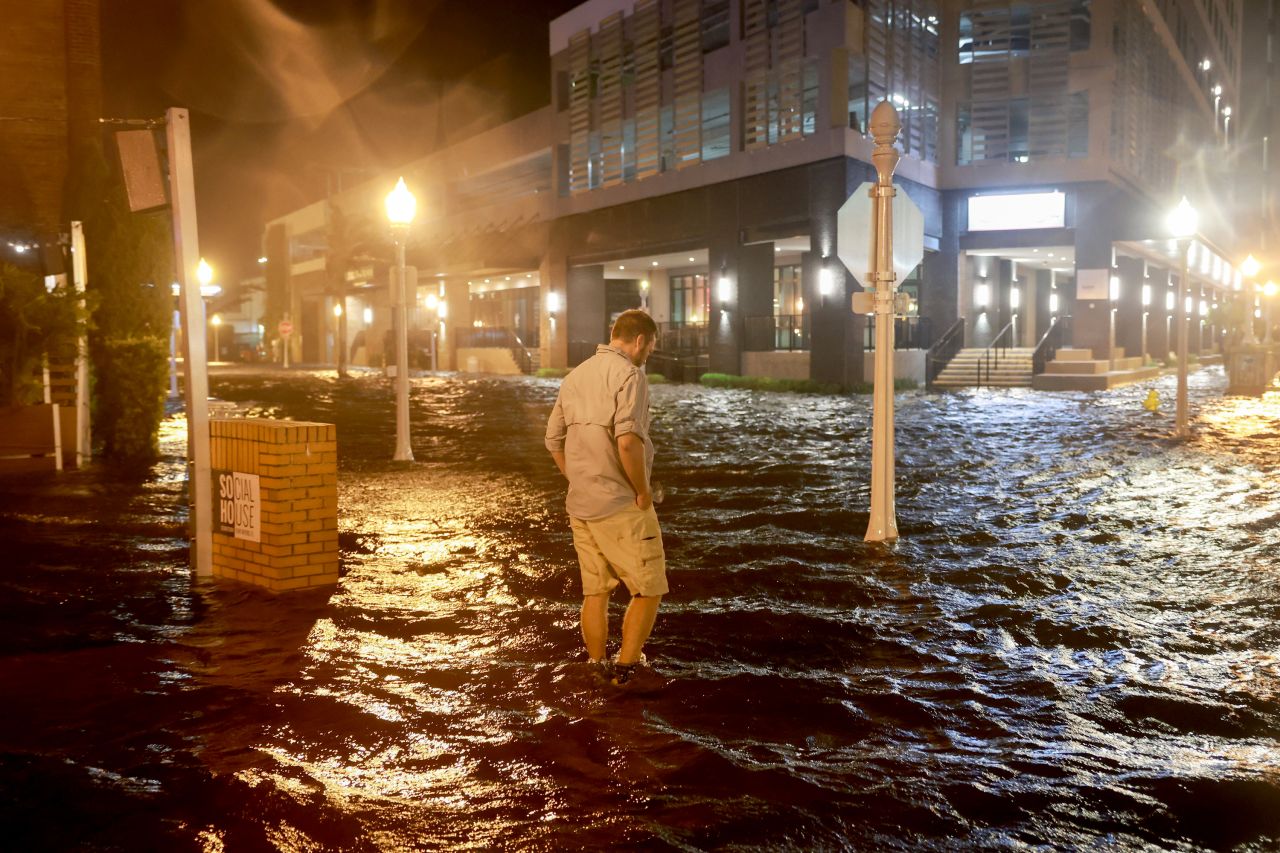 Brandon Marlow walks through a flooded street in Fort Myers, Florida, on Wednesday night.