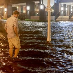 FORT MYERS BEACH, FLORIDA - OCTOBER 09: Brandon Marlow walks through surge waters flooding the street after Hurricane Milton came ashore in the Sarasota area on October 09, 2024, in Fort Myers, Florida. People are waiting to assess the damage after the Cat 3 hurricane came ashore. (Photo by Joe Raedle/Getty Images)