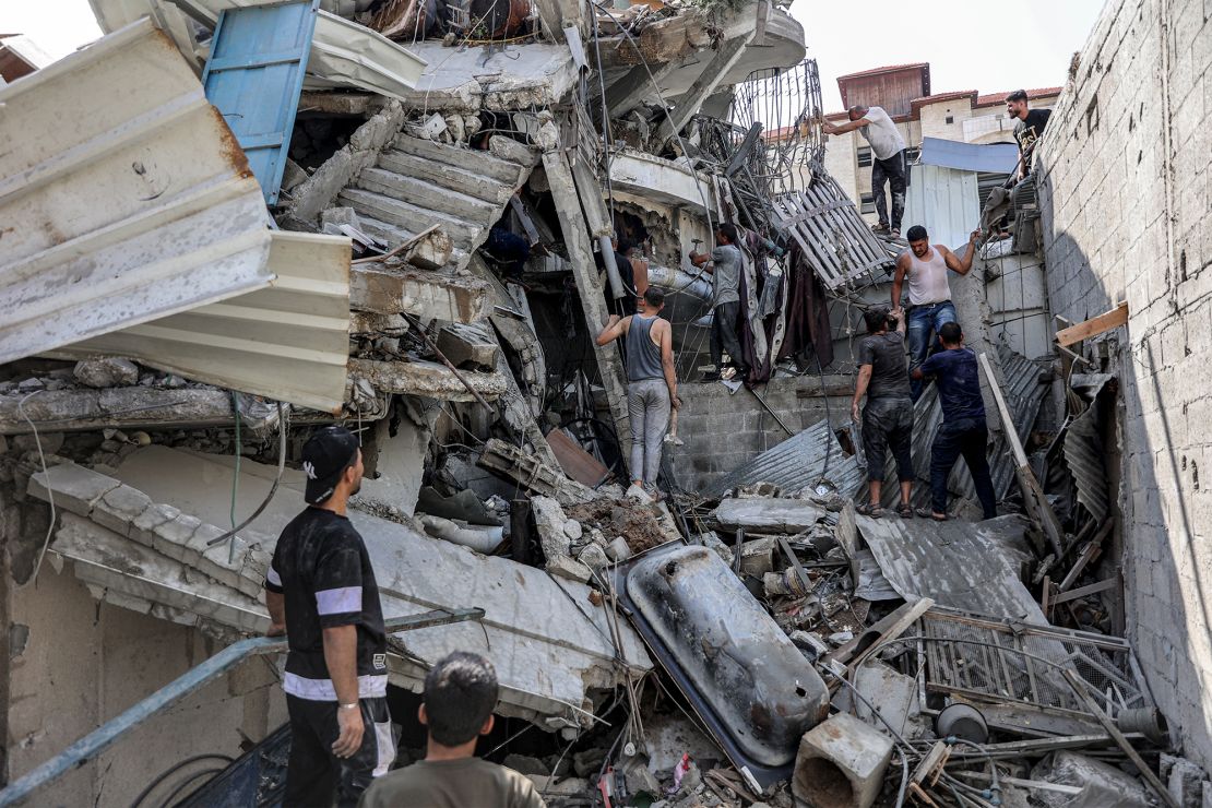 Palestinians gather outside a building razed by an Israeli strike in Jabalya, in northern Gaza, on Tuesday, as they attempt to recover a man from underneath the rubble.